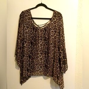 Shark bite style, animal print blouse with decorative detail in the back.
